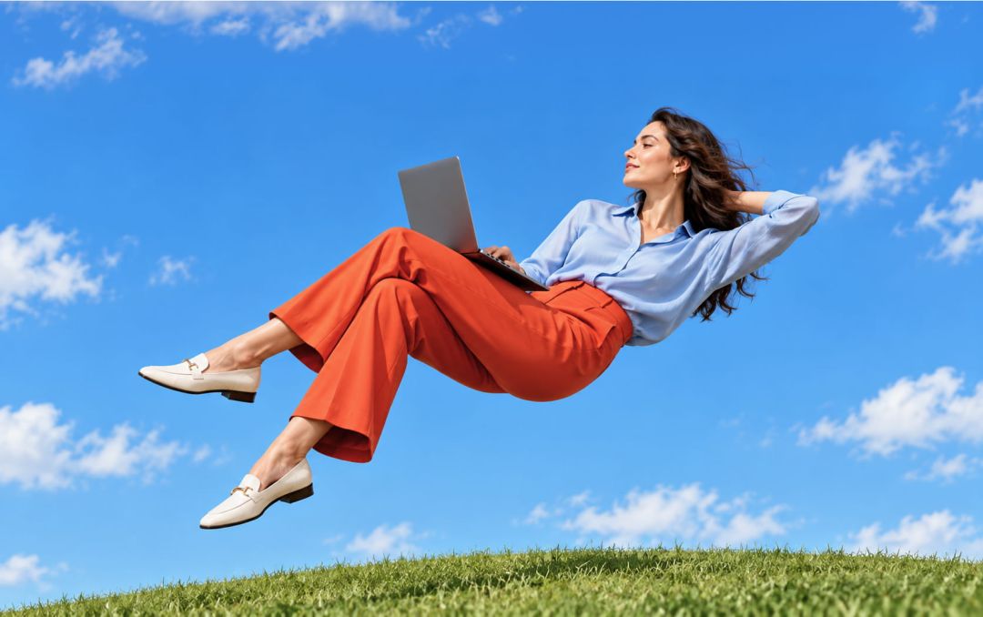 A relaxed client floats in a clear blue sky with a laptop.
